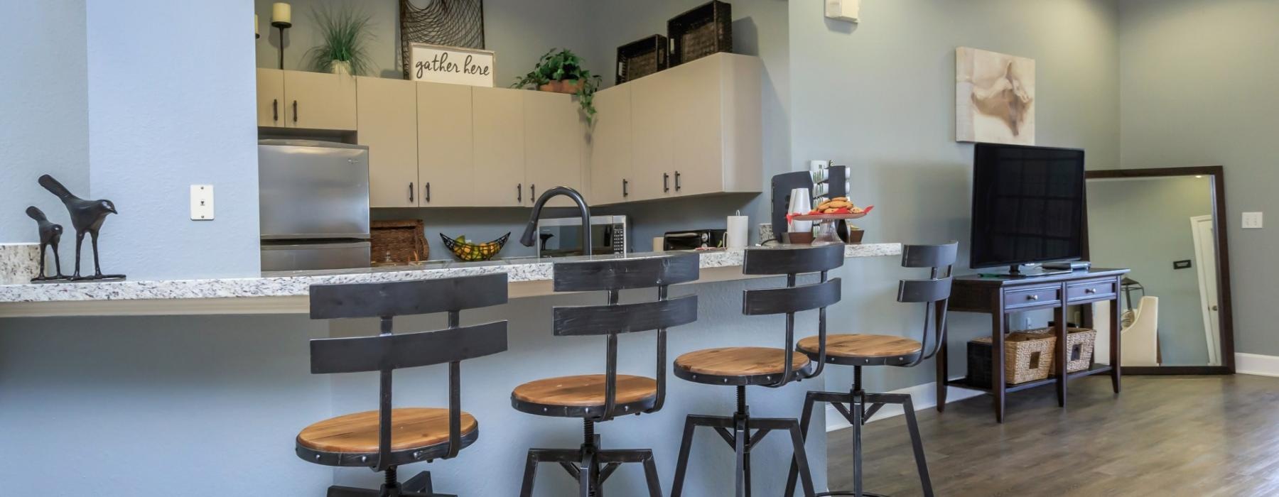 a kitchen with stools and a bar