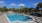 a pool with a deck and trees in the background