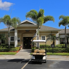 Find your perfect fit at Vero Green Apartments a building with palm trees and a golf cart in front of it