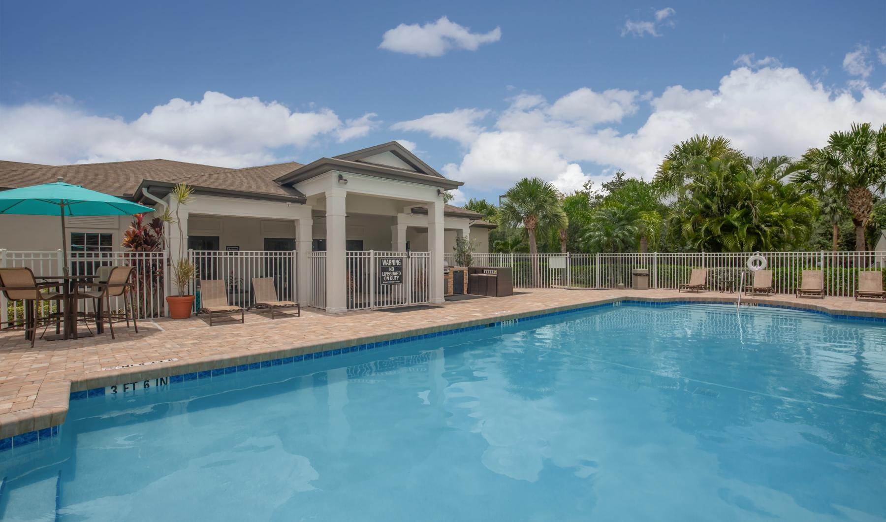 a swimming pool with a house in the background